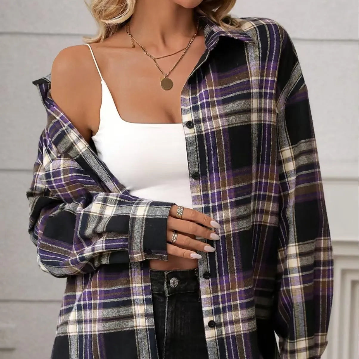 Woman wearing a loose-fit black and white plaid long sleeve shirt made from 100% cotton.