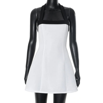 Elegant black and white mini dress with halter neckline, sleeveless design, and short skirt length