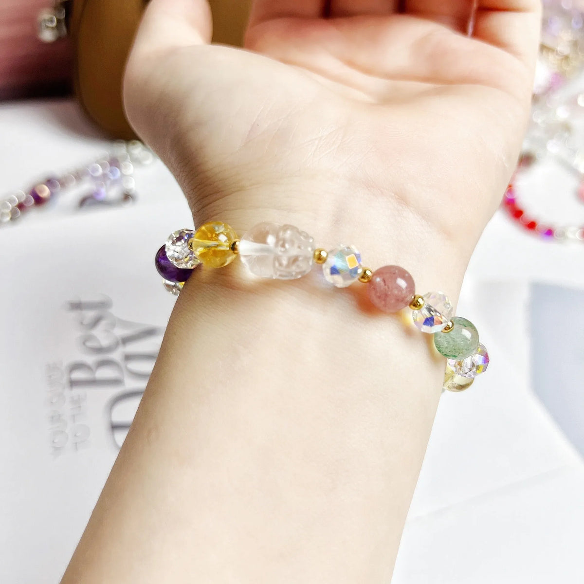 Close-up of a handmade crystal bracelet with a detailed nine-tailed fox design on a wrist.