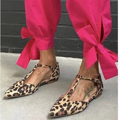 Women's leopard print pointed toe pumps with a low chunky heel and cross shoulder straps.