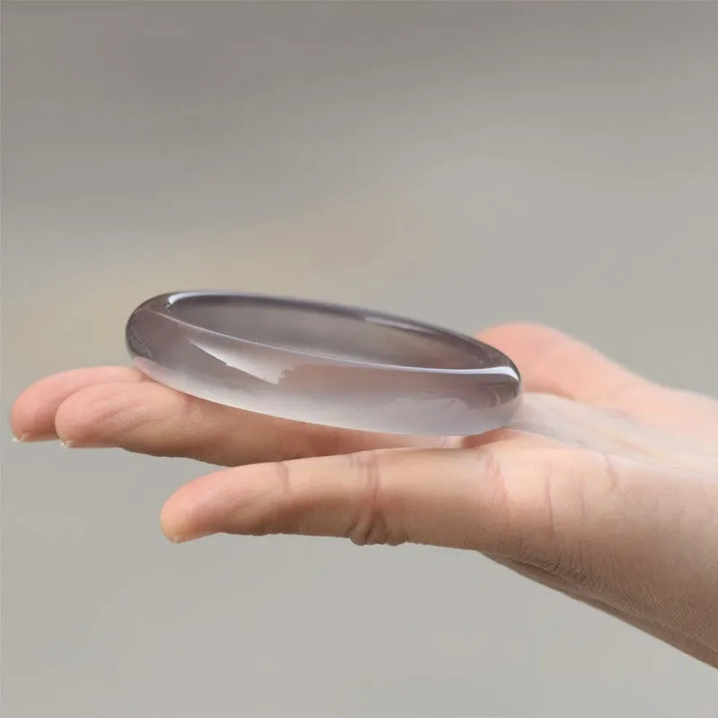 Dark gray Brazilian agate women's bracelet with circle and ring design on a wrist.