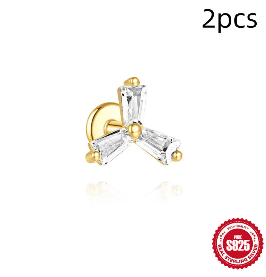 Close-up of a sterling silver double piercing chain stud earring with inlaid zircon stone in a golden colour.
