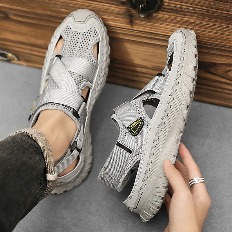 Men's gray casual sandals with mesh panels, leather upper, elastic strap, and rubber sole.