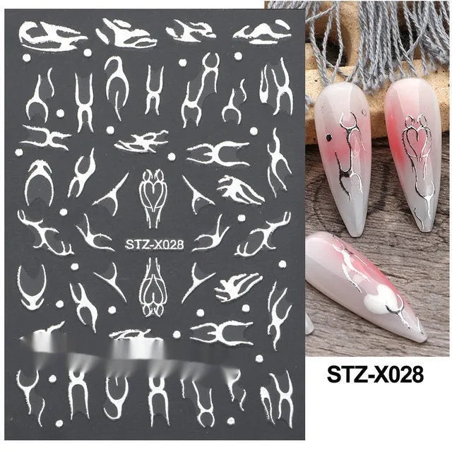 Assortment of black and silver nail sticker designs including cartoon and French tip patterns on a plastic sheet.