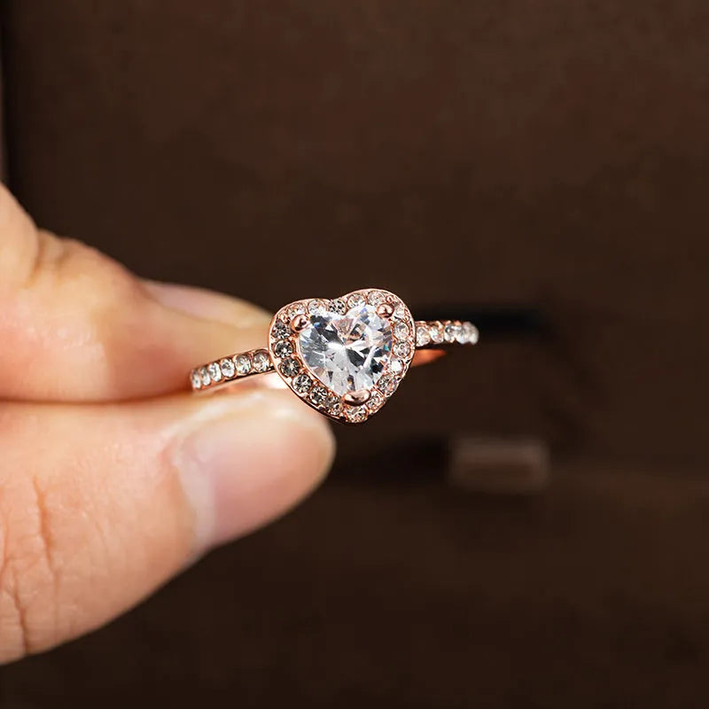Women's heart-shaped crystal ring in rose gold or silver tone on white copper.