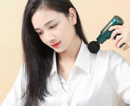 Black electric muscle massage gun with four different coloured massage heads on a grey background.