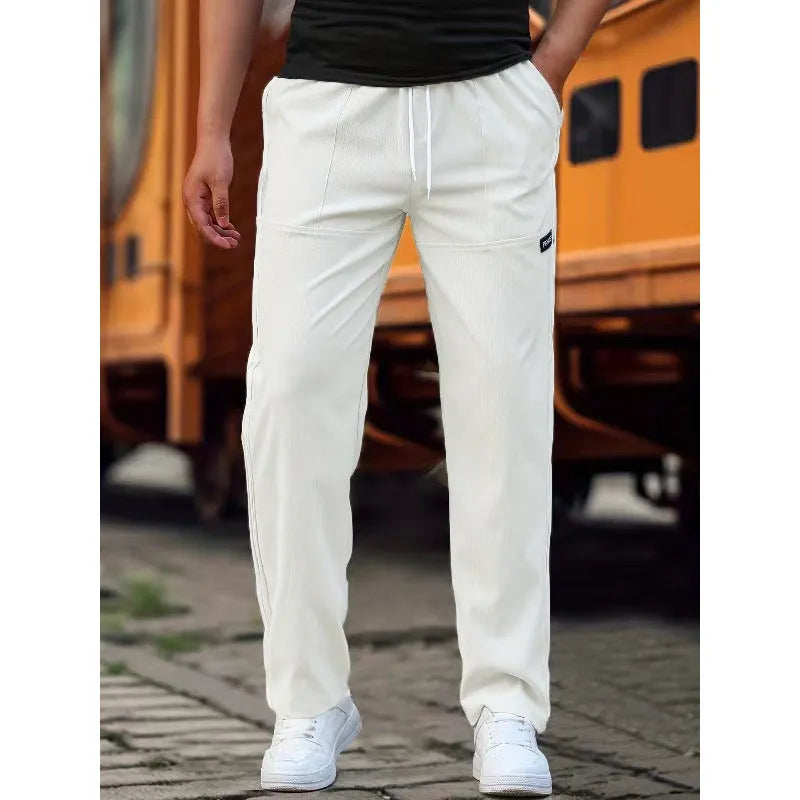Men's light grey polyester trousers with an elasticated waistband laid flat