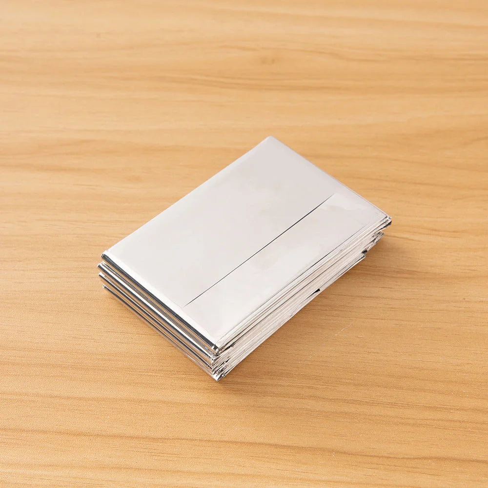 Portable double-sided silver emergency thermal blanket for outdoor adventures and survival situations