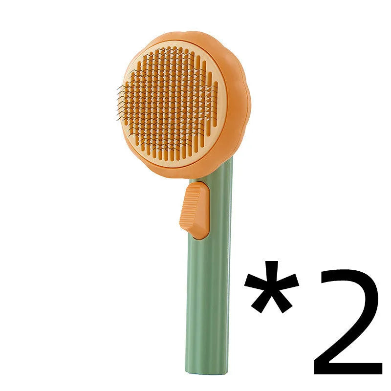 Hand-held pumpkin-coloured pet brush with stainless steel needles for grooming cats and dogs