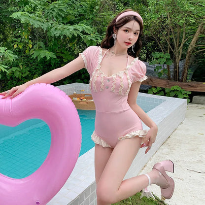 Pink women's conservative one-piece swimsuit with Siamese design on a hanger