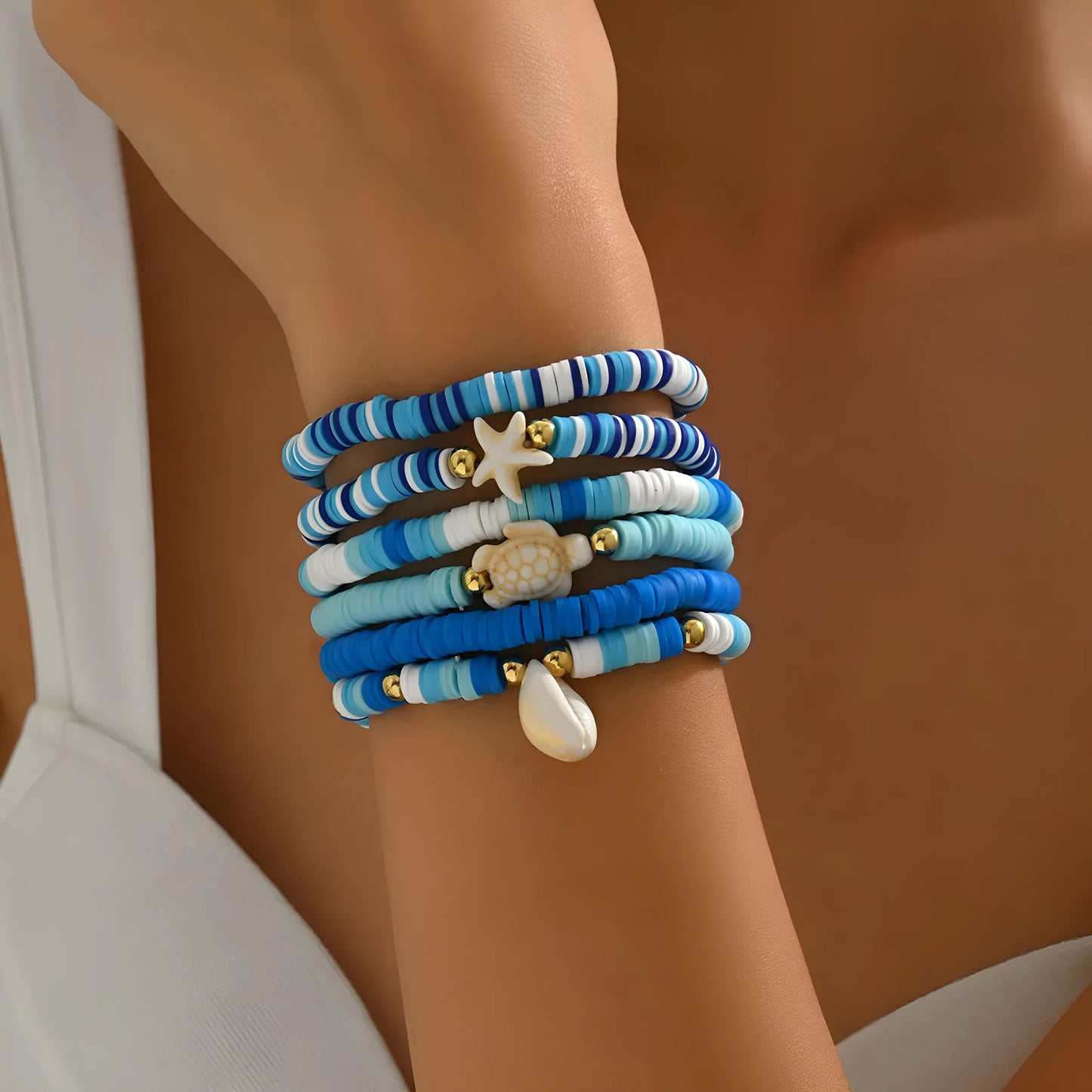Six handmade Bohemian Blue polymer clay bracelets with geometric shell designs arranged together