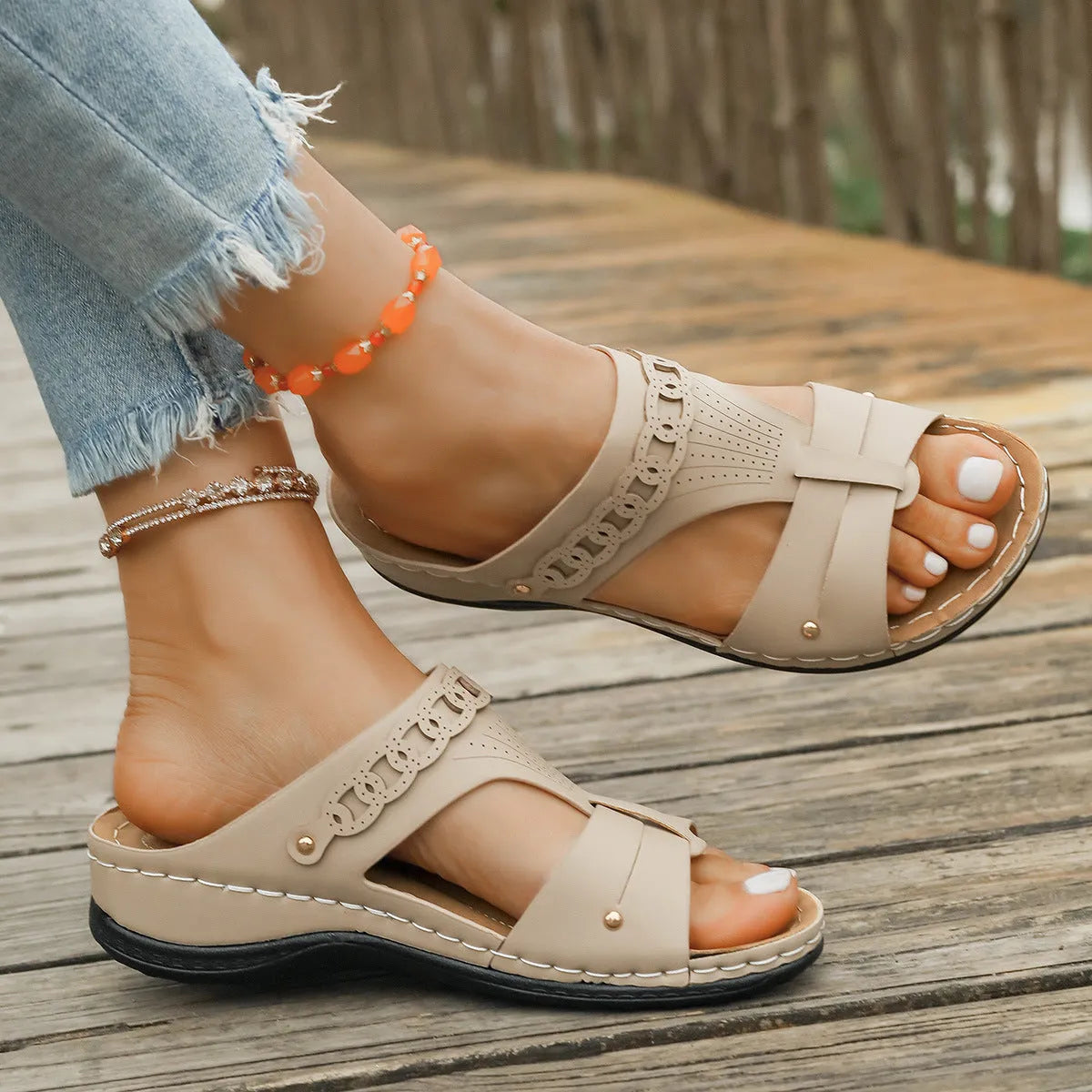 Beige Roman style slippers with a fish mouth toe, slope heel, and rubber sole.