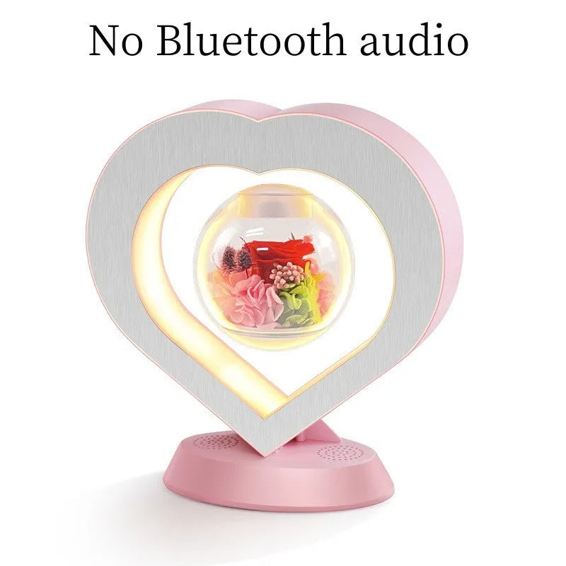 Pink rose eternal flower floating in magnetic levitation LED night light with triangular base and touch control