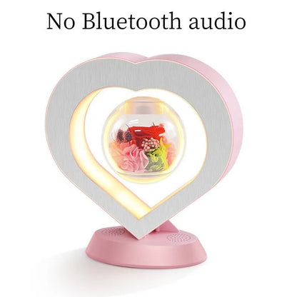 Pink rose eternal flower floating in magnetic levitation LED night light with triangular base and touch control