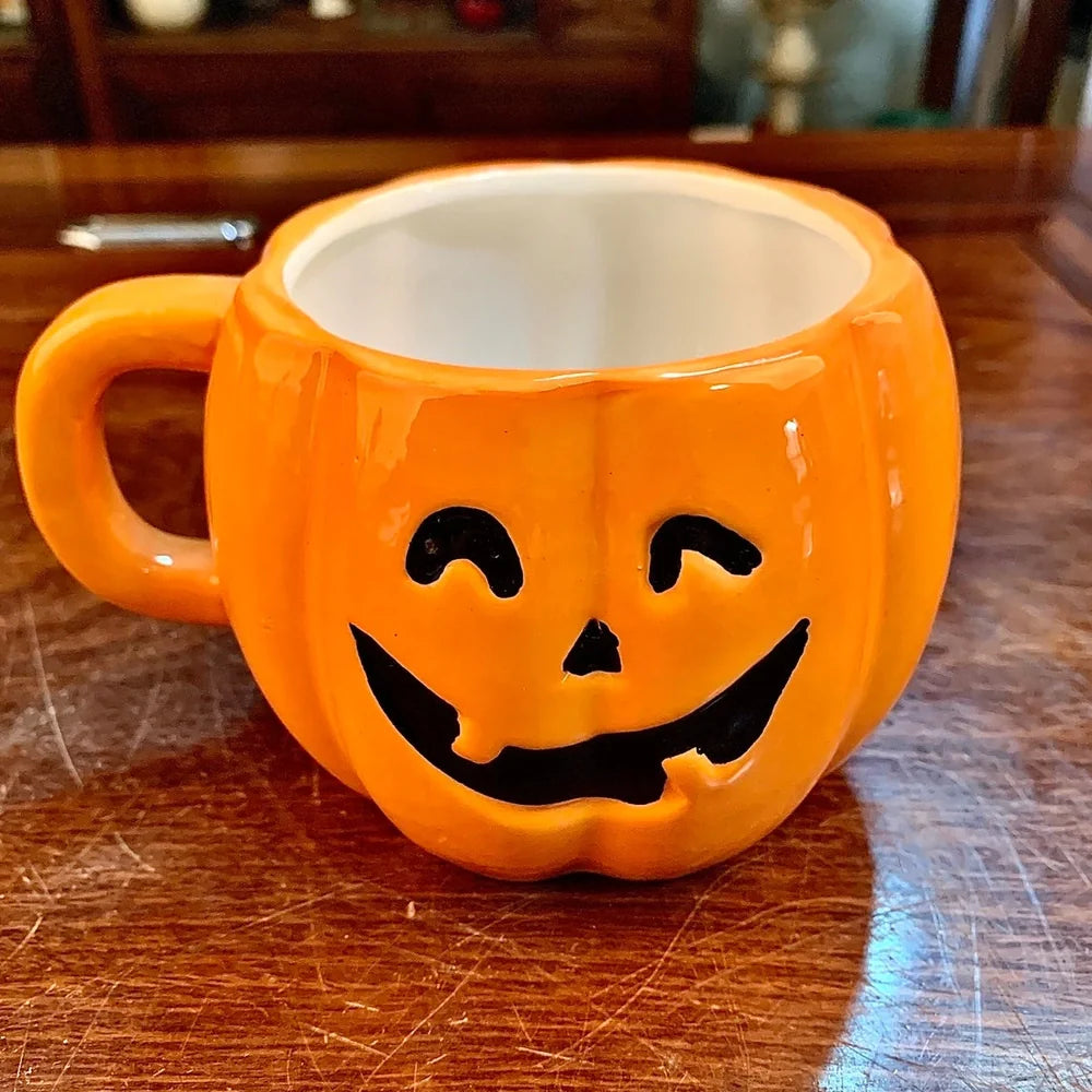 Ceramic Halloween pumpkin mug with cartoon face, 350ml capacity, 7.5cm diameter, includes matching spoon for seasonal drinks