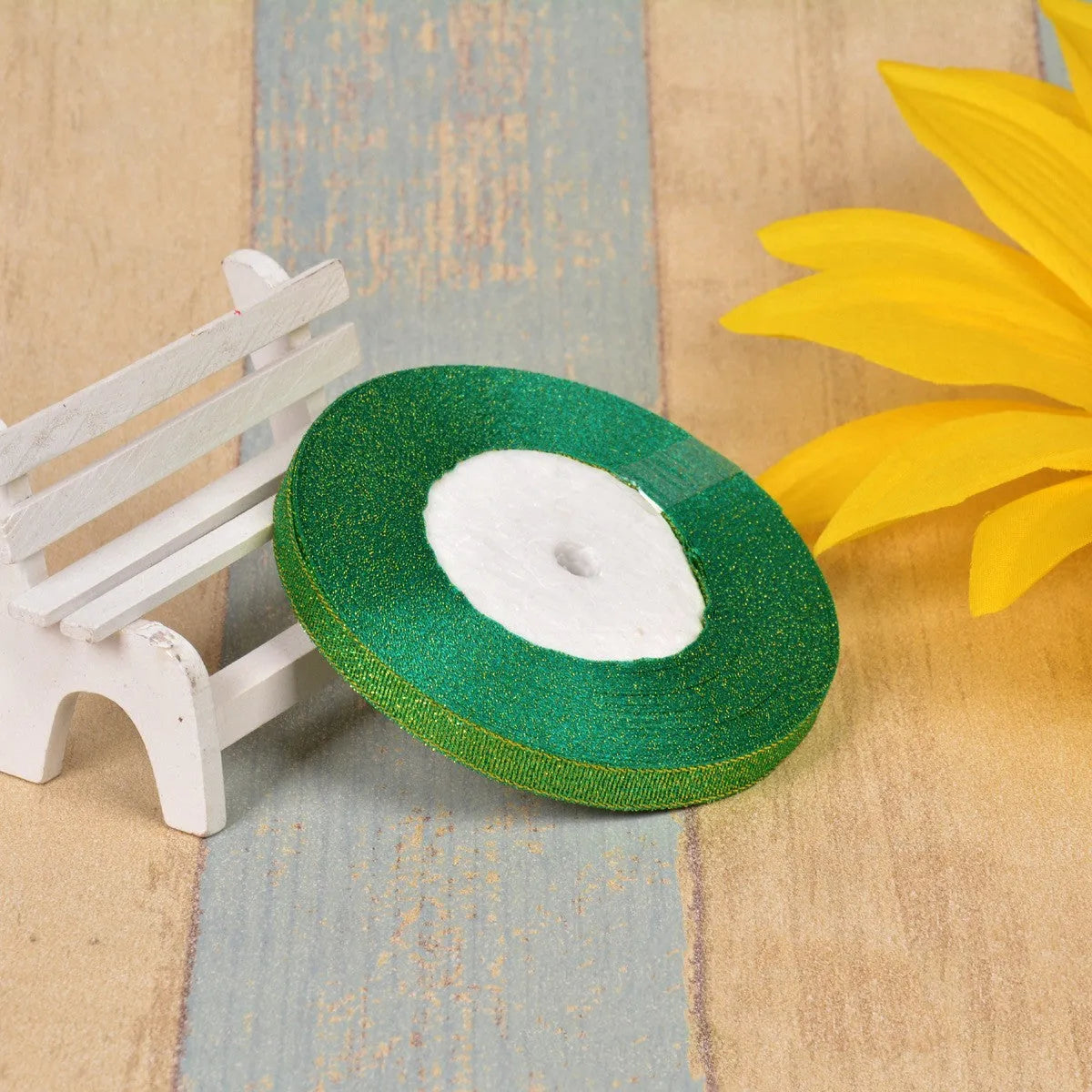 Close-up of green onion patterned ribbon with gold wire on a 25-yard roll, showing 3-points width.
