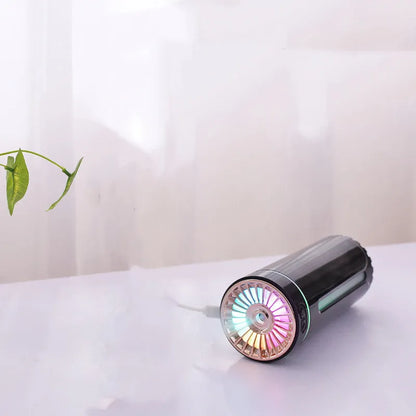 Black portable humidifier with LED lights beside car cup holder showing mist output