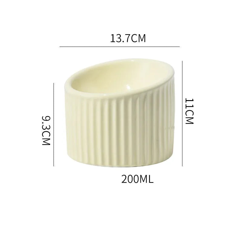 Ceramic elevated cat bowl in green colour showing tilted, round whisker-friendly design.