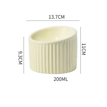 Ceramic elevated cat bowl in green colour showing tilted, round whisker-friendly design.