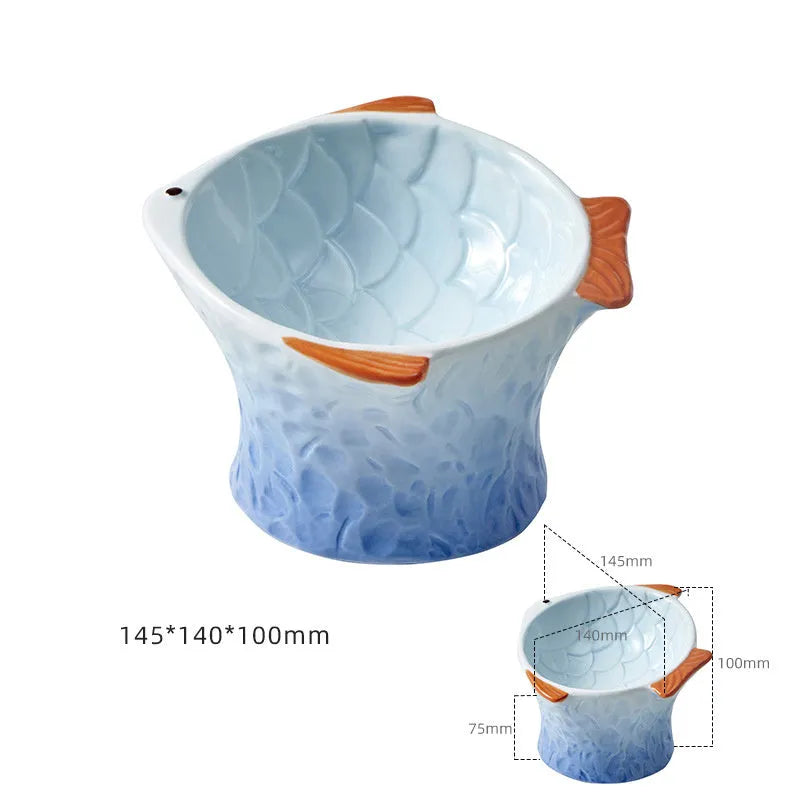 Set of four blue fish-shaped ceramic cat bowls with a tilted design on a wooden floor.