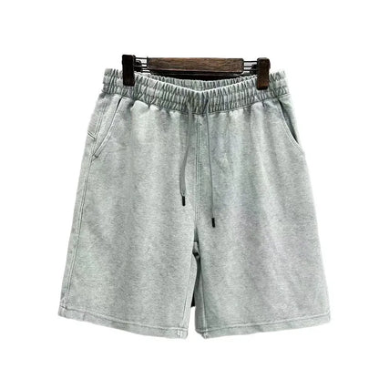 Man wearing loose-fit, straight-leg distressed cotton shorts in a solid colour