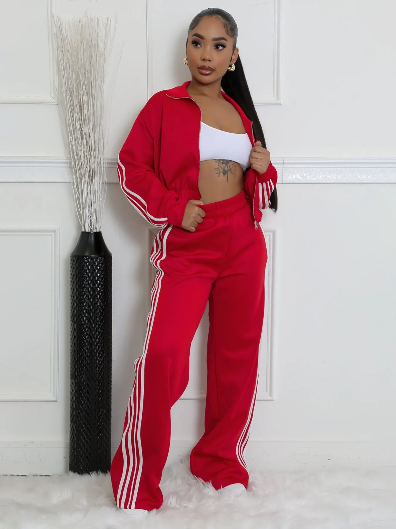 Woman wearing a grey striped zipper sweater and matching trousers from a casual two-piece set.