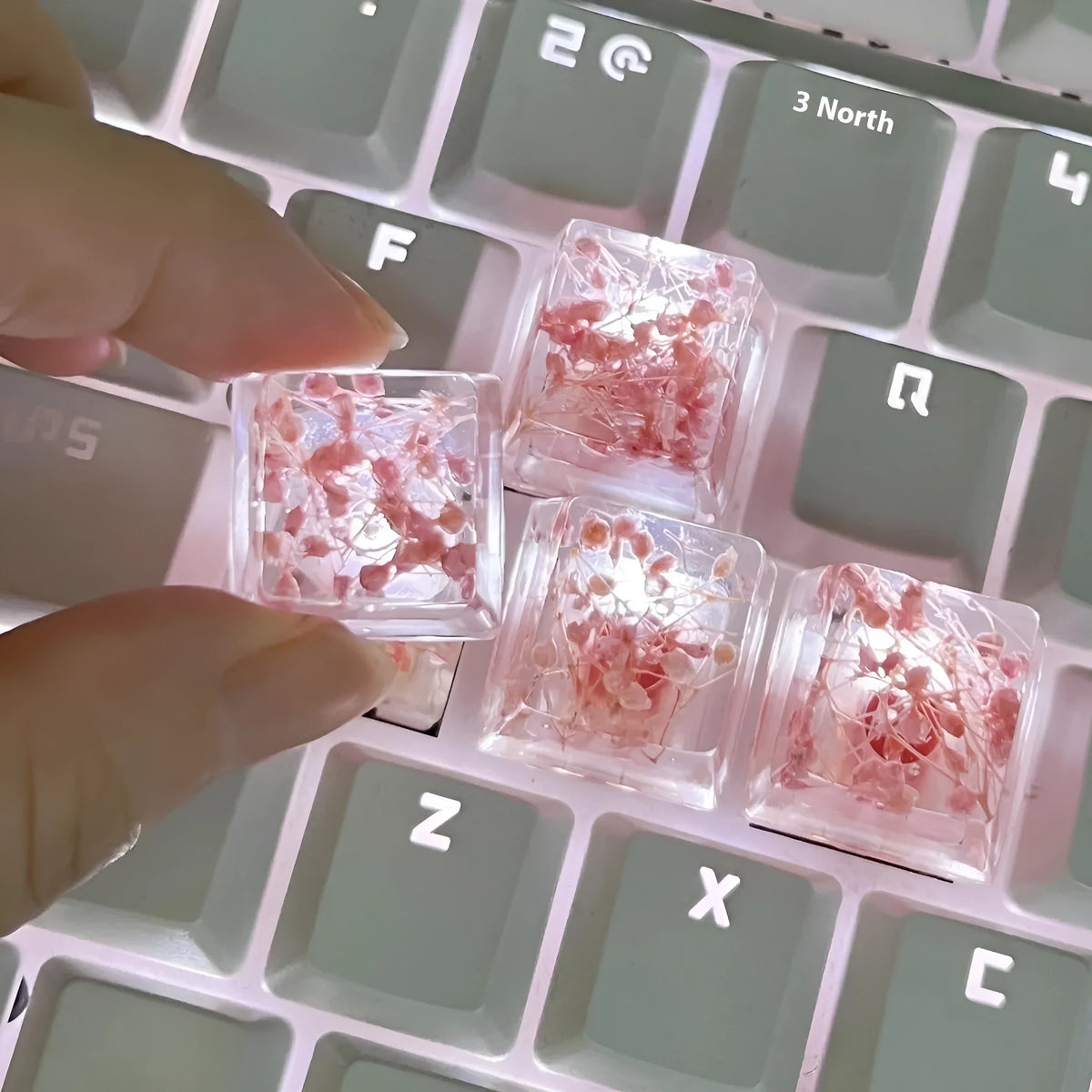 Transparent resin mechanical keyboard keycap with glitter starry sky effect in red, pink, green, or violet.