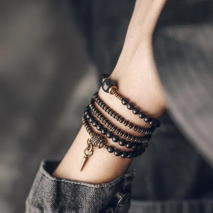 Black geometric beaded bracelet with multi-layered colourful design on wrist