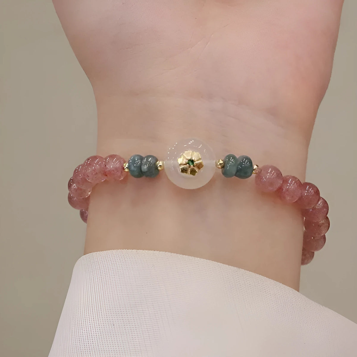 Women's bracelet with strawberry quartz stones and blue water emerald round jade pendant featuring peace buckle closure