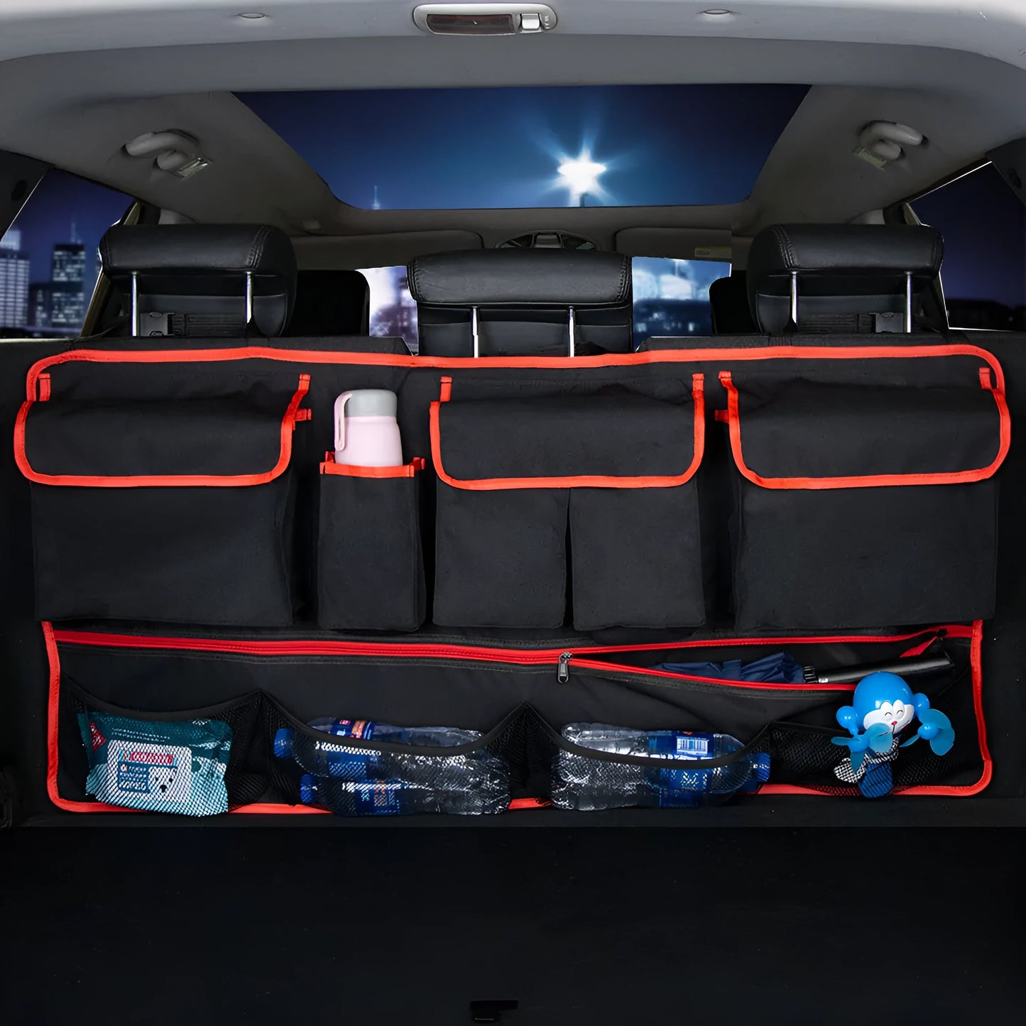 Black car hanging storage bag made of waterproof Oxford cloth with a handle, shown hanging in a vehicle boot.