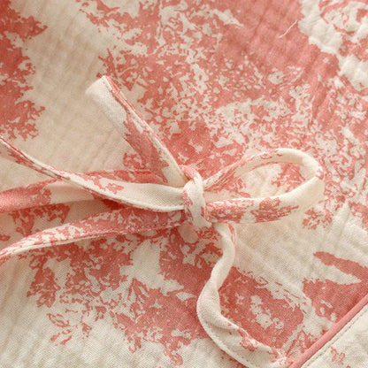 Women's pink pure cotton gauze lace-up top and trousers homewear set laid flat.