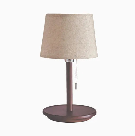 Walnut coloured solid wood bedside lamp with white fabric shade and cable switch.