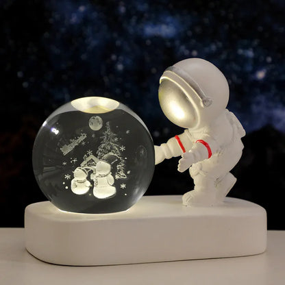 Glowing astronaut crystal ball night light with 6cm diameter and USB cable on wooden surface
