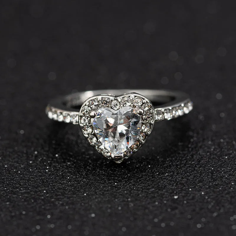 Women's heart-shaped crystal ring in rose gold or silver tone on white copper.