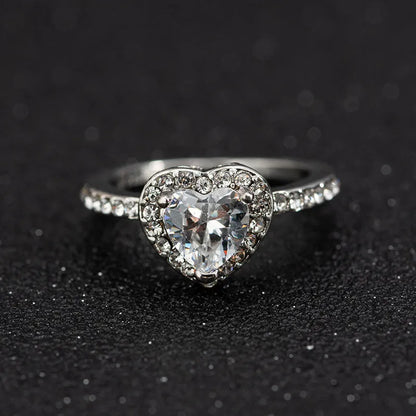 Women's heart-shaped crystal ring in rose gold or silver tone on white copper.