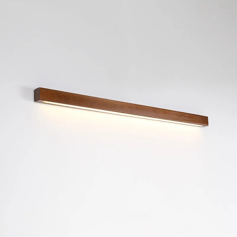 Walnut coloured wooden strip wall lamp with acrylic diffuser, mounted flush on a wall.