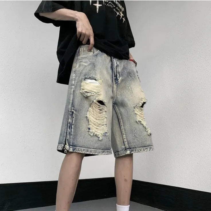 A pair of faded blue denim shorts with a tattered, distressed finish and a loose wide-leg silhouette.