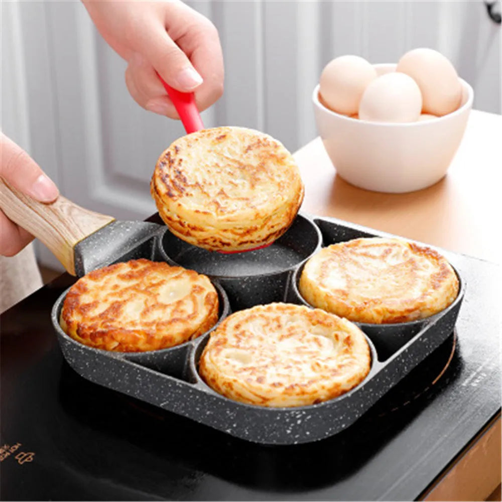 Four-hole aluminium frying pan with medical stone non-stick coating and bakelite handle on a hob
