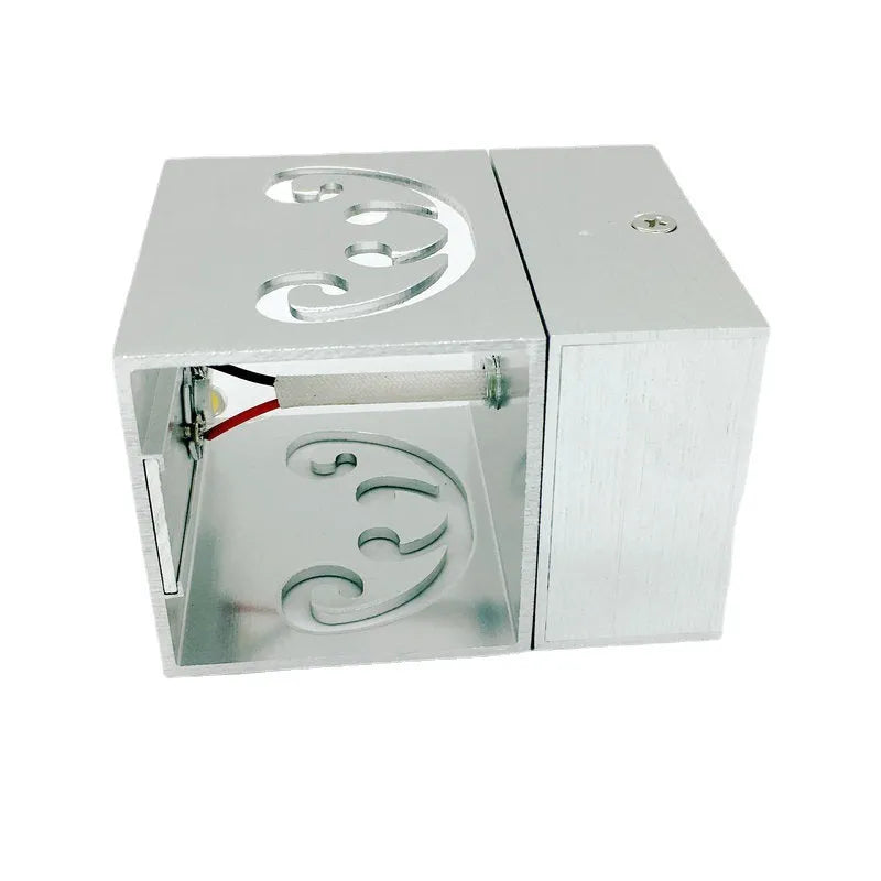 Modern aluminium butterfly-shaped LED wall lamp with colour-changing lights on a plain wall