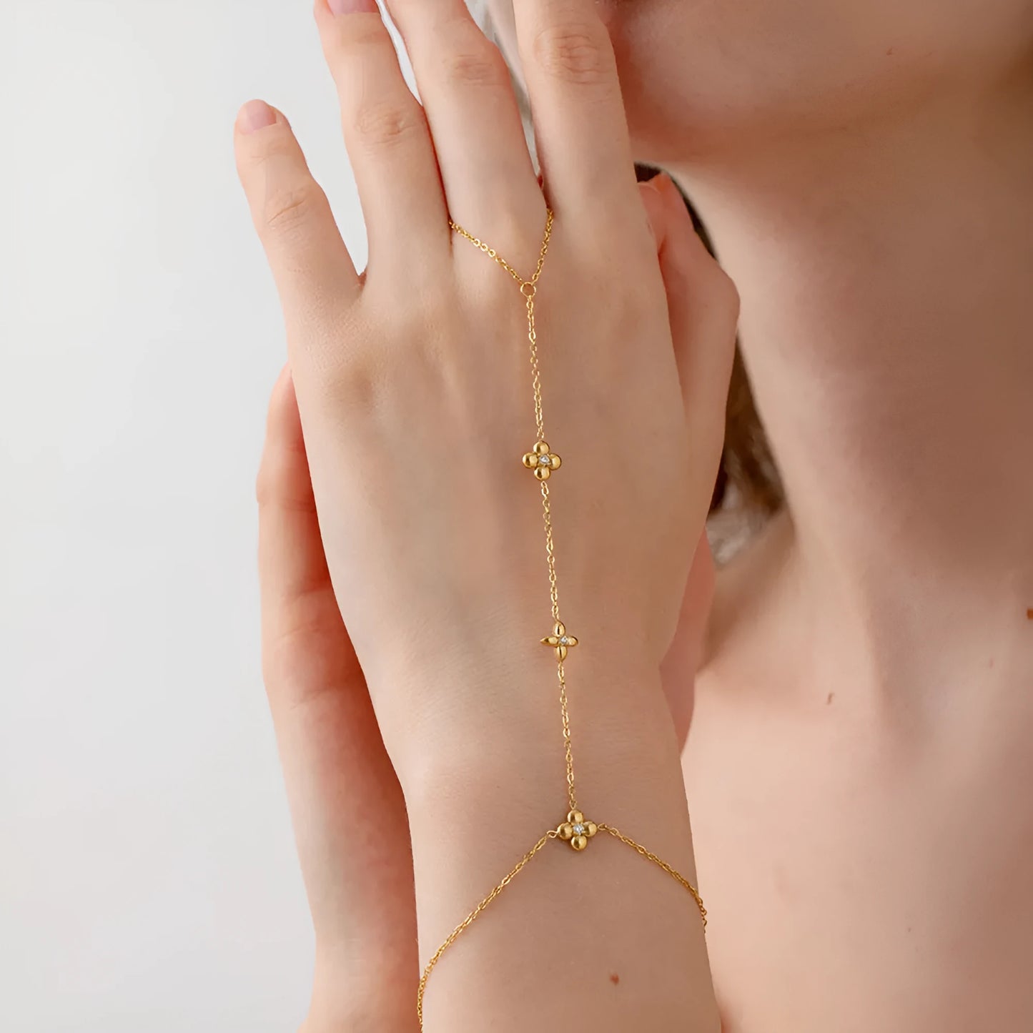 Gold stainless steel women's bracelet with geometric design of eight pointed stars and flowers.