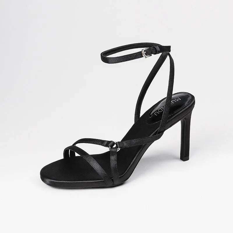 Black satin ankle-strap high heel sandals with 8cm heel, round toe, and buckle fastening