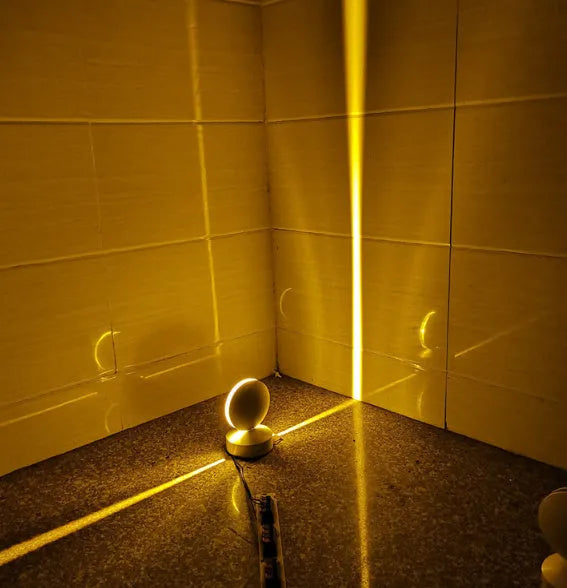 Modern linear aluminium wall spotlight bar with a glass lens, mounted as an accent light.
