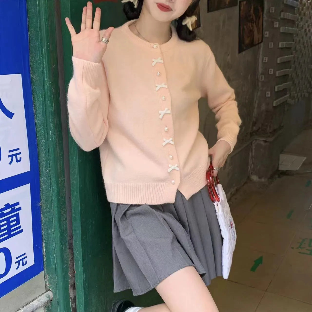 Women's acrylic cardigan sweater with pearl button bow detail in light yellow colour