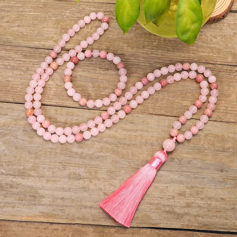 Natural stone bead necklace and bracelet set with a long fringe tassel pendant on a table.