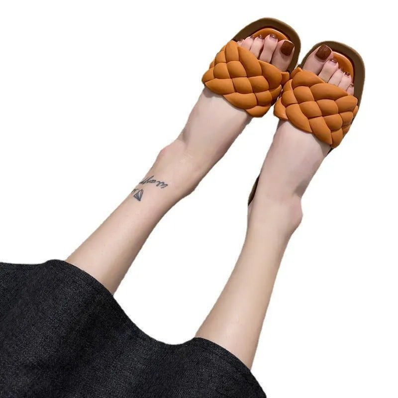 Women's white PVC beach sandals with a thick, patterned sole on a sandy background.