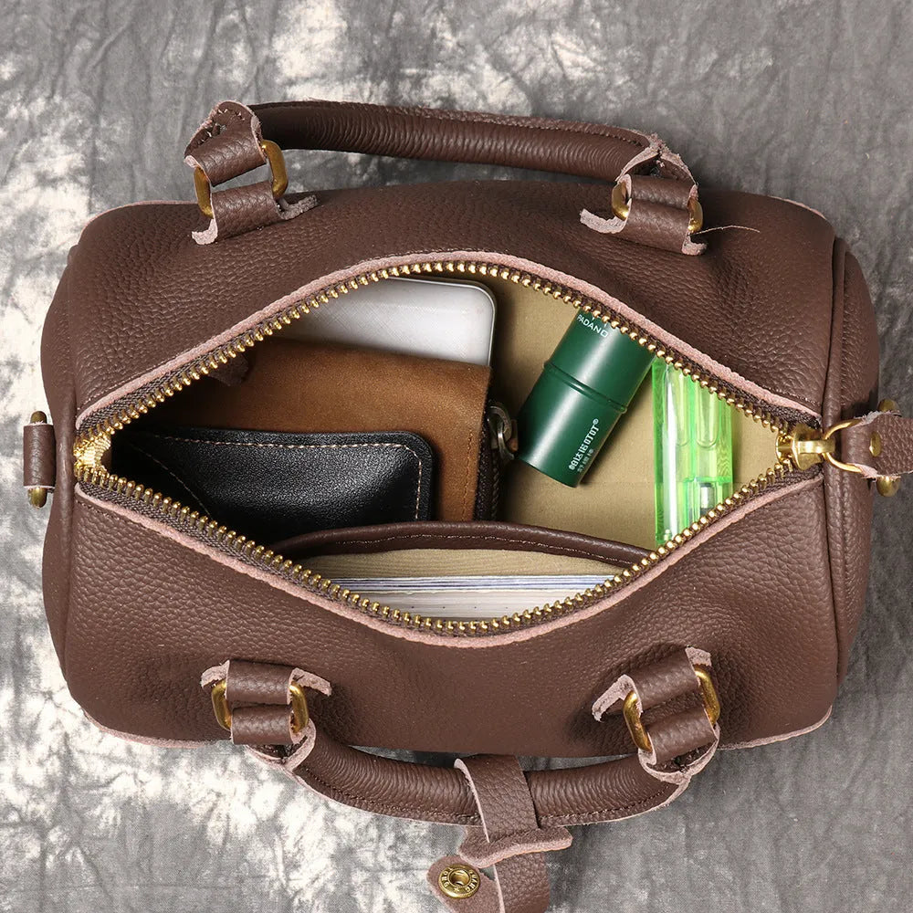 Handmade cylindrical brown Boston bag made from first layer cowhide leather with a single shoulder strap.