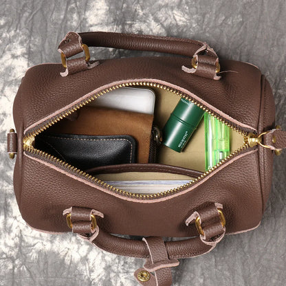 Handmade cylindrical brown Boston bag made from first layer cowhide leather with a single shoulder strap.