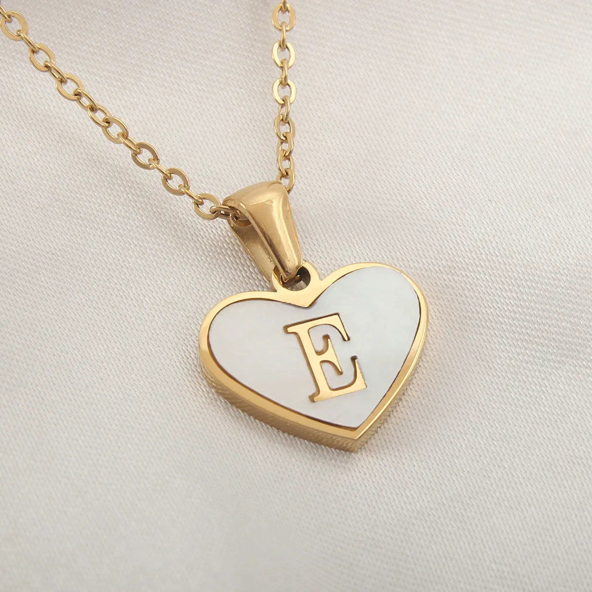 Gold-plated heart necklace with white shell pendant showing letter personalisation option