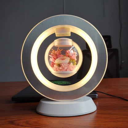 Pink rose eternal flower floating in magnetic levitation LED night light with triangular base and touch control