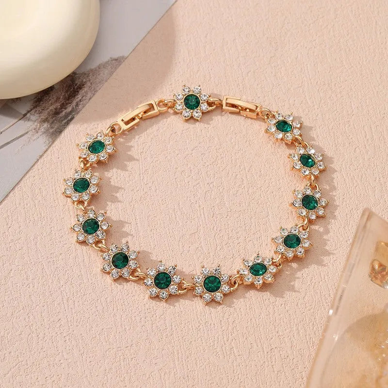 Gold and silver electroplated bracelets with flower charms set with coloured gemstones.
